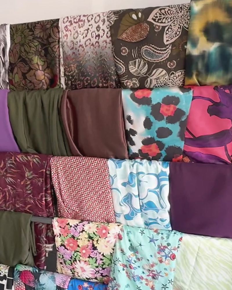 Expositor con telas estampadas y lisas colgadas en filas ordenadas